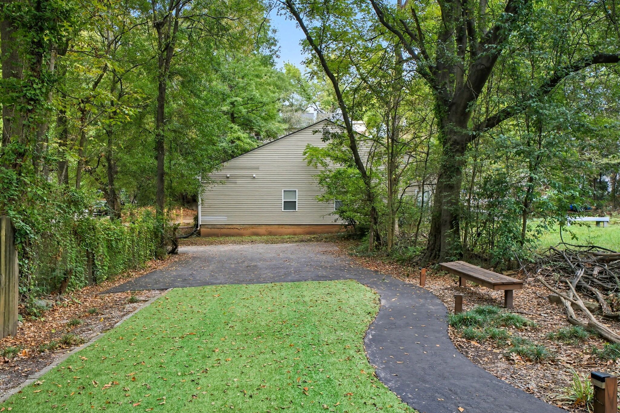 A pathway leading to a house surrounded by trees.