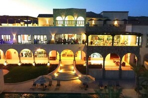 A hotel with a central courtyard, multiple balconies, and a pool area.