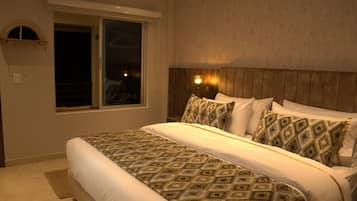 Un dormitorio con una cama grande, una ventana y un cabecero con apliques.