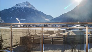 Bergblick vom Balkon bei blauem Himmel.