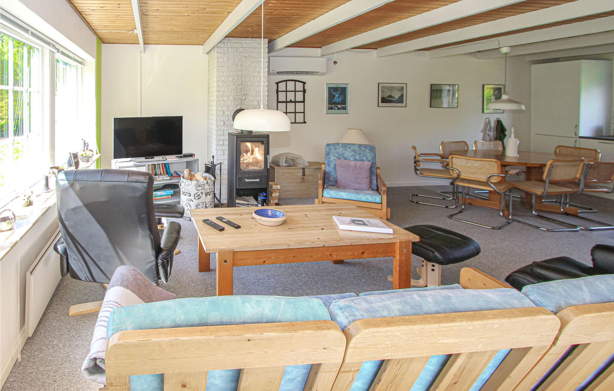 Een woonkamer met televisie, open haard, bank en een eethoek.