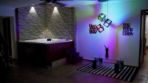 Een moderne badkamer met een stenen muur, een ligbad en een glazen tafel met een vaas.