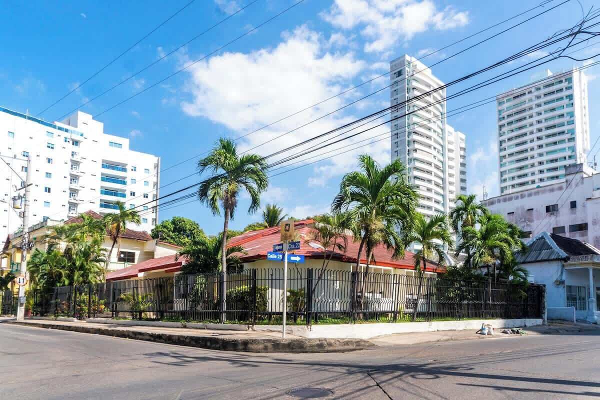 A street view with a building that has a red roof and a sign indicating 'Calle 25'.