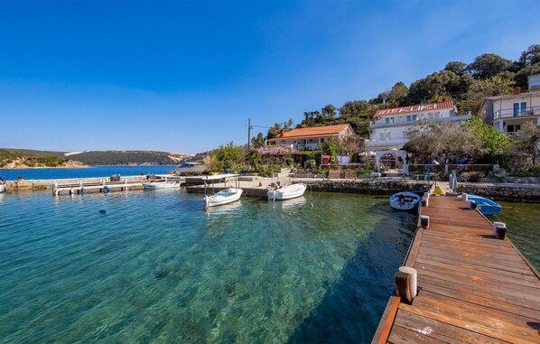 Overlooking the calm sea, this property offers a tranquil retreat with a pier and stunning views of the surrounding hills.