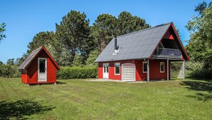 Ett rött trähus med en stor veranda och ett mindre, sammanbyggt förråd.