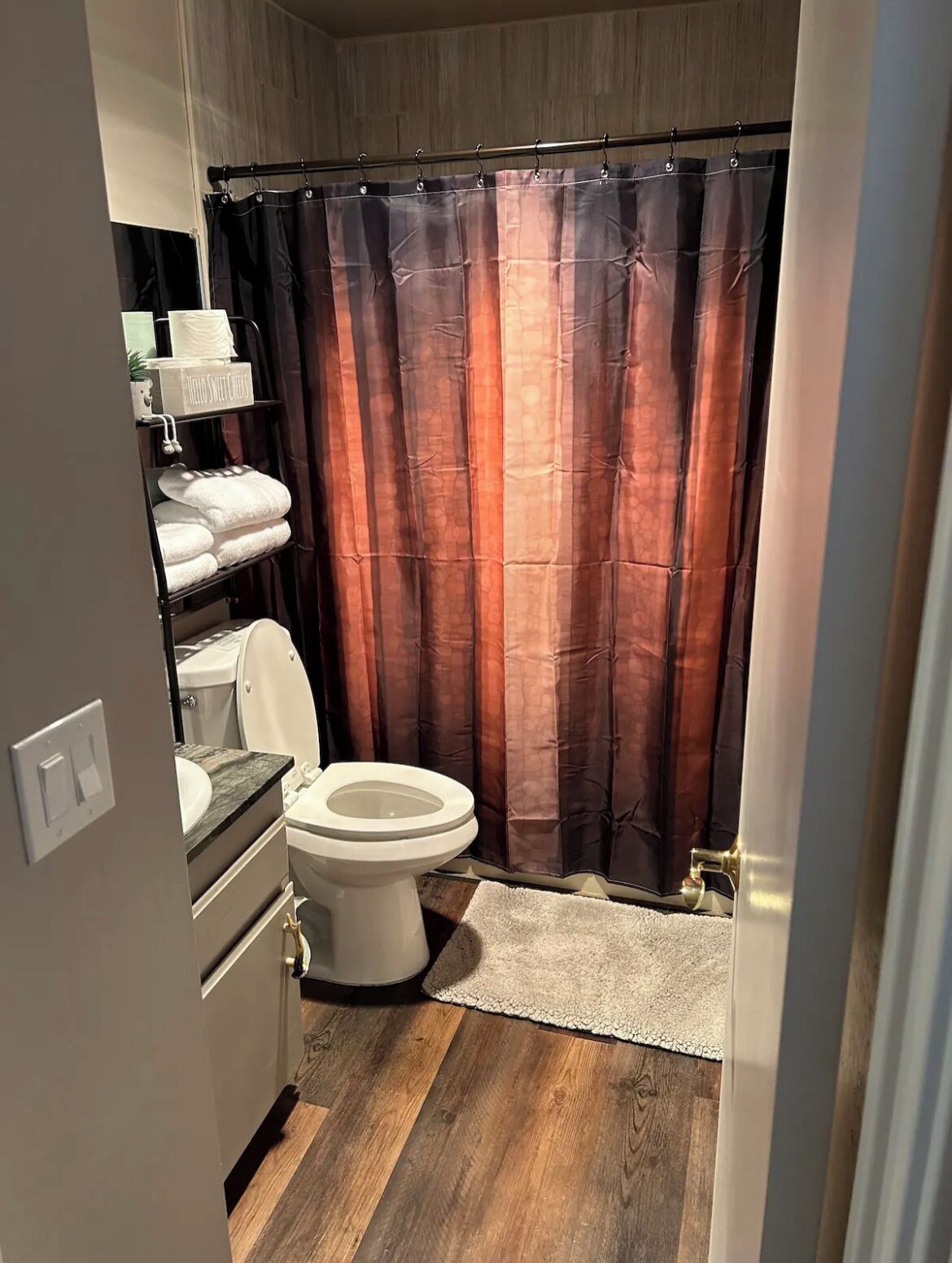 Un baño moderno con inodoro, lavabo y cortina de ducha.