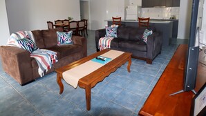A living room with two sofas, a coffee table, and a TV stand. - BLK Stays Guest House Deluxe Back Units Morayfield (Morayfield)