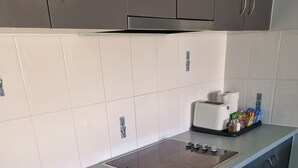 A modern kitchen with grey cabinets, a black oven, and a built-in stovetop. - BLK Stays Guest House Deluxe Back Units Morayfield (Morayfield)