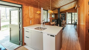 A modern kitchen with a built-in dishwasher, wooden cabinetry, and a large window. - Stunning home in Samsø with WiFi (Samsø)