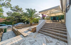 Relax in a shaded seating area surrounded by lush greenery and palm trees.