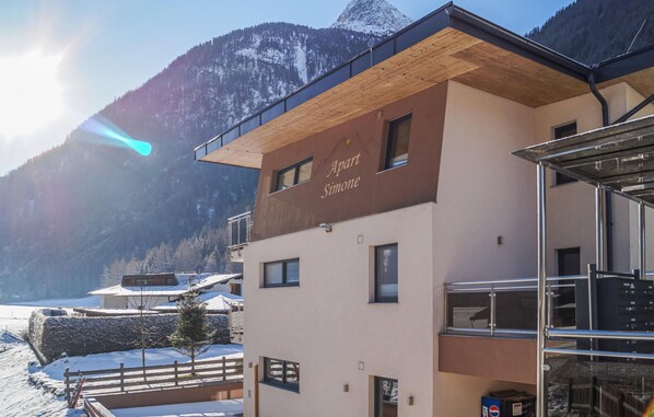 A modern building with a sign reading "Apart Simone" and a view of snow-covered mountains in the background. - Beautiful apartment in Längenfeld with WiFi (Längenfeld)