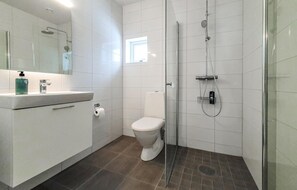 A modern bathroom with a glass shower enclosure, a toilet, and a sink with a mirror above it. - Stunning home in Båstad with WiFi (Båstad)