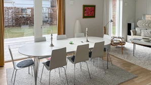 A modern dining area with a round table, six chairs, and a candle centerpiece. - Stunning home in Båstad with WiFi (Båstad)