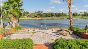 Un parc au bord du lac, doté d’une promenade dallée, de bancs et de palmiers.
