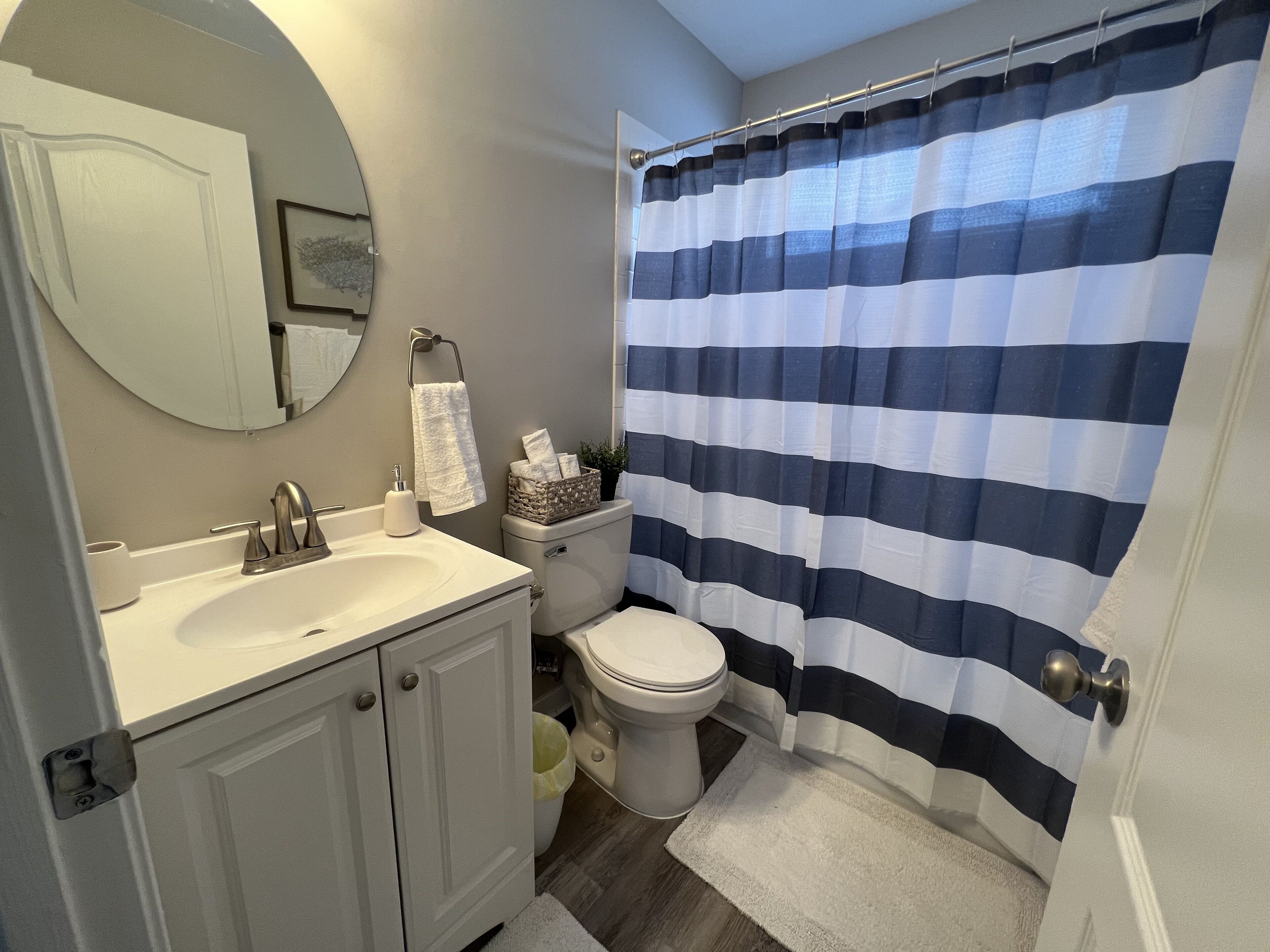 Un baño con lavamanos blanco, inodoro y cortina de ducha.