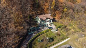 A two-story house with a green roof, surrounded by trees and a garden. - Stunning home in Madzarevo with sauna (Madzarevo)
