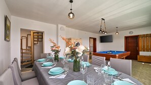 A dining area with a long table set for six, a pool table, and a staircase leading to an upper floor. - Stunning home in Madzarevo with sauna (Madzarevo)