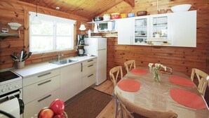 Une cuisine compacte équipée d’un évier, d’une cuisinière et d’une table à manger pour quatre personnes.
