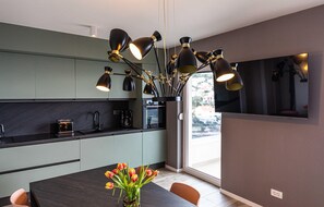 Enjoy cooking in this well-lit kitchen with a central island and large flat-screen TV.