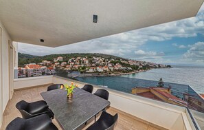 Enjoy the serene views of the coastal town from this balcony, overlooking the sea.