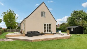 A house with a large deck, a black shed, and a grassy yard. - 3 bedroom stunning home in Samsø (Samsø)