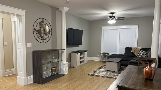A living room with a dark wood dining table, a black sofa, and a white entertainment unit. - Vintage Home in Portage, WI (Portage)