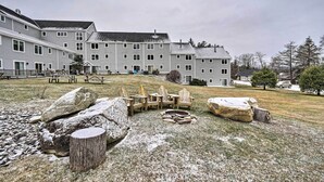 Ein mehrstöckiges Gebäude mit Innenhof, Außenbestuhlung und Feuerstelle.