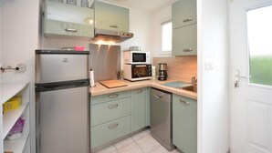 A compact kitchen with a refrigerator, microwave, coffee maker, and a sink. - Cozy home in Aigues-Mortes with WiFi (Aigues-Mortes)