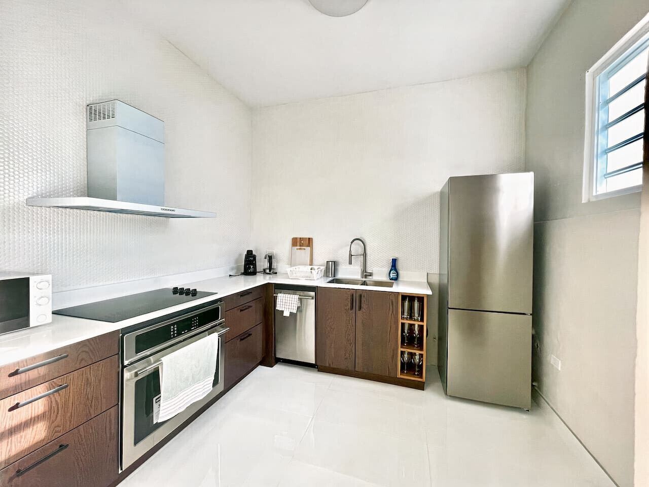 A modern kitchen with stainless steel appliances, wooden cabinets, and a built-in oven.