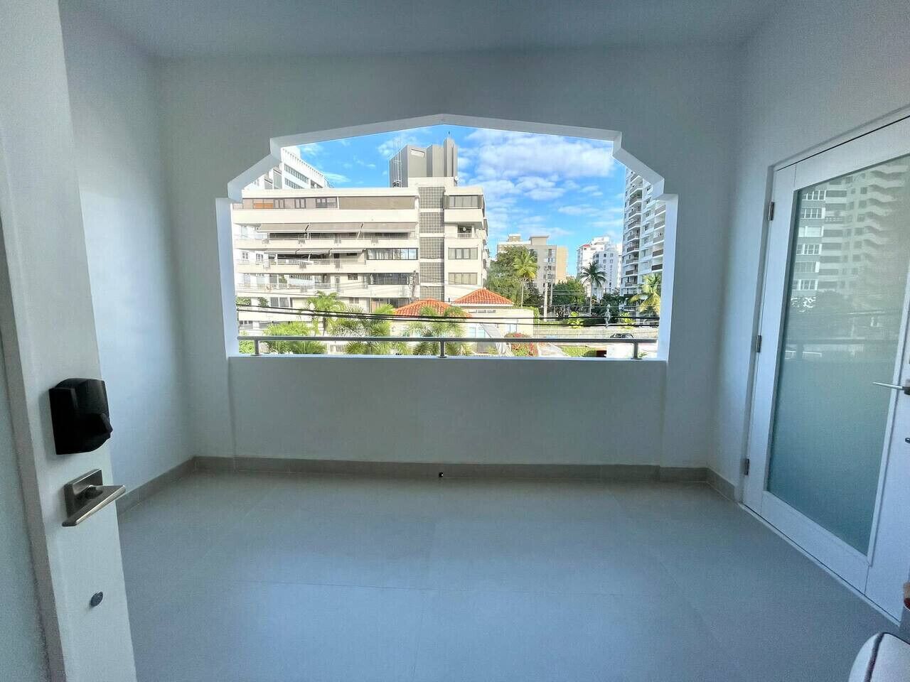 A balcony with a view of modern buildings and a clear sky.