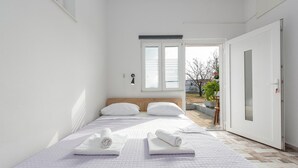 Een slaapkamer met een bed, twee kussens, een bedlampje en uitzicht op het omliggende landschap.