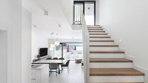 A modern kitchen with a dining area, a staircase, and a view of the outdoors. - Amazing home in Dramalj (Dramalj)