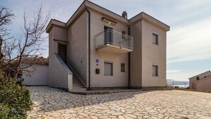 A modern building with a balcony, a staircase, and a stone-paved entrance. - Beautiful apartment in Ribarica (Ribarica)