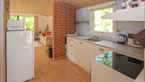 Pieni, käytännöllinen keittiö, jossa on jääkaappi, pesuallas ja mikroaaltouuni.
