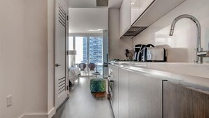 Una cucina moderna con lavello in acciaio inossidabile, forno integrato e finestra con vista sulla città.