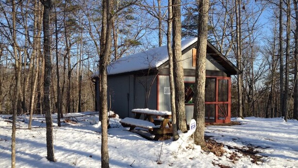 A cabin in a snowy forest with a picnic table and a covered area. - Cabin in Bankhead National Forest (Moulton)