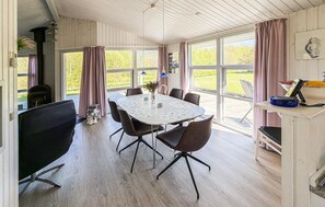 A dining area with a table, chairs, and a view of the outdoors.