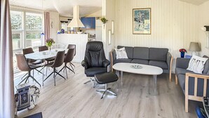 Ett rymligt vardagsrum med ett matbord, stolar, en soffa och ett soffbord.
