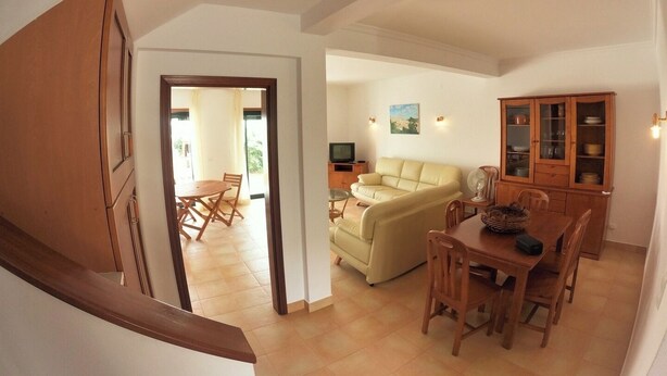 A spacious living area with a sofa, dining table, and wooden cabinets. - Algarve, 4 Bedrooms Independent House, Pêra (Pêra)