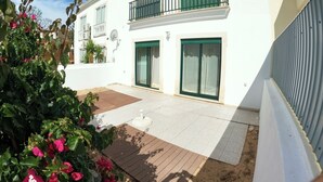 A two-story building with a balcony, large sliding doors, and a paved patio area. - Algarve, 4 Bedrooms Independent House, Pêra (Pêra)
