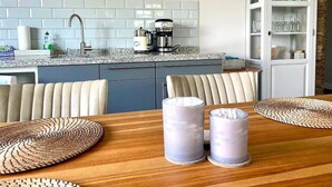 A modern kitchen with white subway tiles, a coffee machine, and a cabinet with glassware. - Vacation apartment "Belt" with two bedrooms - close to the beach - on the island of Fehmarn (Fehmarn)