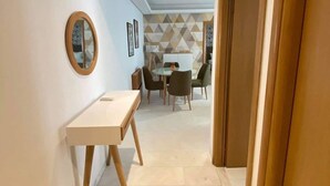 A hallway with a round table and chairs, a small desk, and a mirror on the wall. - Apparently new ideal for family (Avignon)