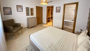 A bedroom with a bed, a chair, a dresser, a wardrobe, and a hanging light fixture. - Apparently new ideal for family (Avignon)