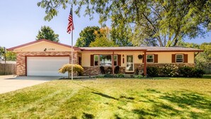 A two-story house with a garage, a small porch, and a well-maintained lawn. - Welcome to Holiday House! Cozy, modern home 7 min. from the beach and wineries. (Stevensville)