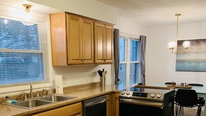 A kitchen with wooden cabinets, a stainless steel stove, and a dishwasher. - Welcome to Holiday House! Cozy, modern home 7 min. from the beach and wineries. (Stevensville)