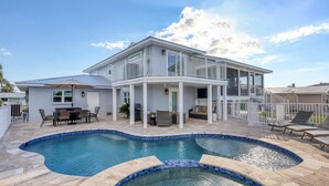 Une maison à deux étages dotée d’une piscine, d’un espace extérieur aménagé et d’un patio couvert.