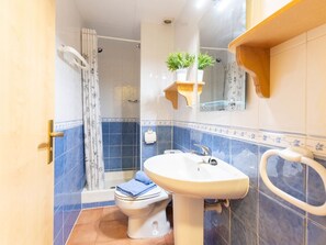 Een badkamer met toilet, wastafel en douche.