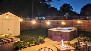 A backyard with a hot tub, a barbecue grill, and a fire pit. - Bourbon House 4 - The Wellingmoor - Hot Tub (Louisville)