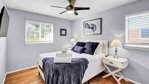 A bedroom with a bed, bedside tables, a ceiling fan, and a window. - Bourbon House 4 - The Wellingmoor - Hot Tub (Louisville)