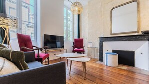 Een moderne woonkamer met een open haard, een televisie en een groot raam.